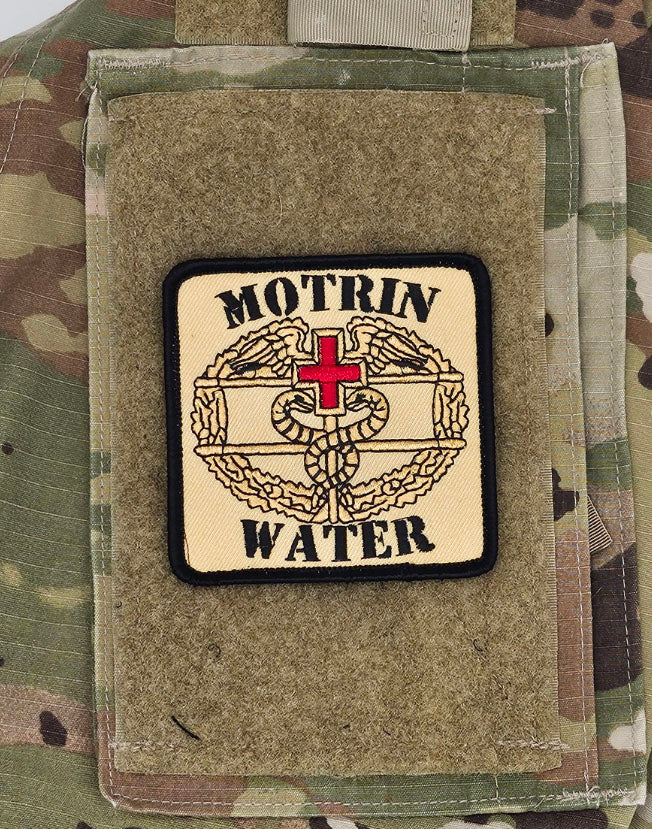 Patch on a camouflage surface with 'MOTRIN WATER' text and design. Also has the army medical insignia.