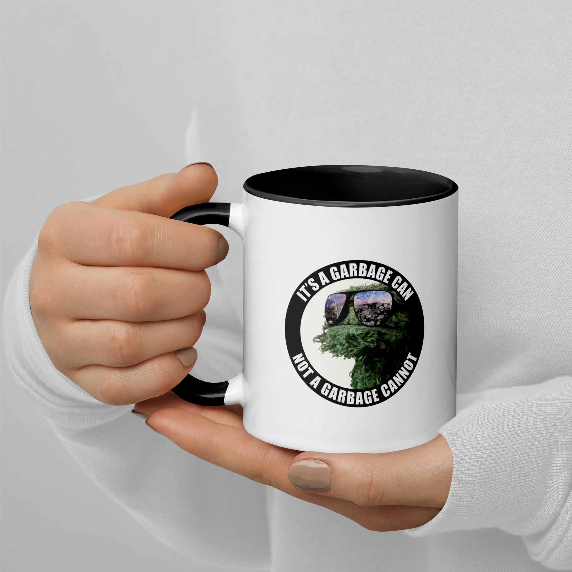 Coffee Mug white outside and black interior with It's a Garbage Can, not a Garbage Cannot in a circle. with Oscar the grouch in the center.