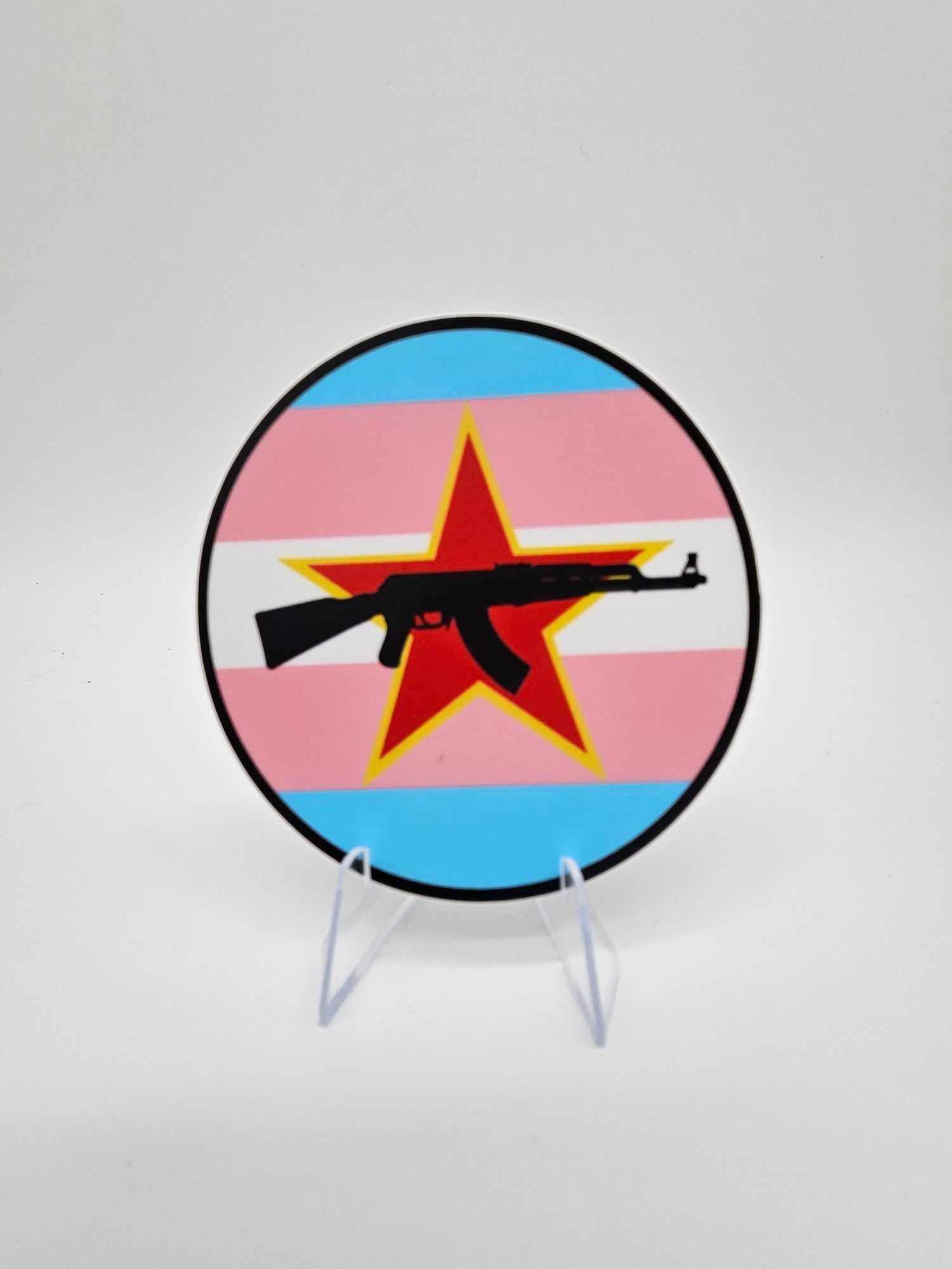 Three inch round sticker. The Trans flag with a red star and an AK-47
