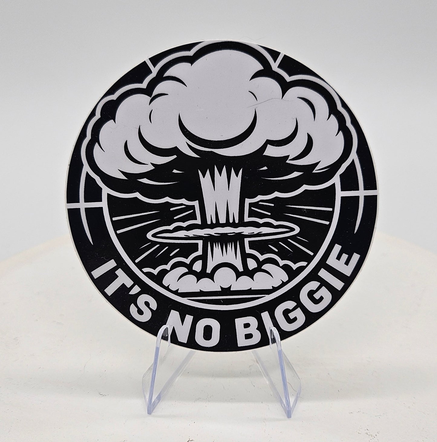 a three inch vinyl sticker with nuclear explosion design and 'It's No Biggie' text on a stand.