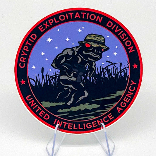 Circular sticker with a frog in a hat and carrying a rifle, surrounded by text on a white background