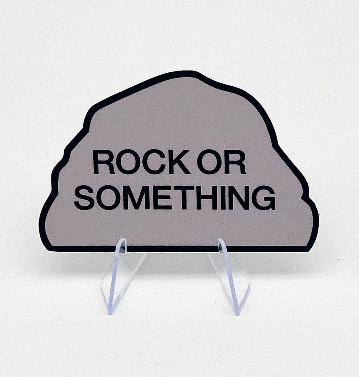 Decorative sign shaped like a rock with 'Rock or Something' text on a white background