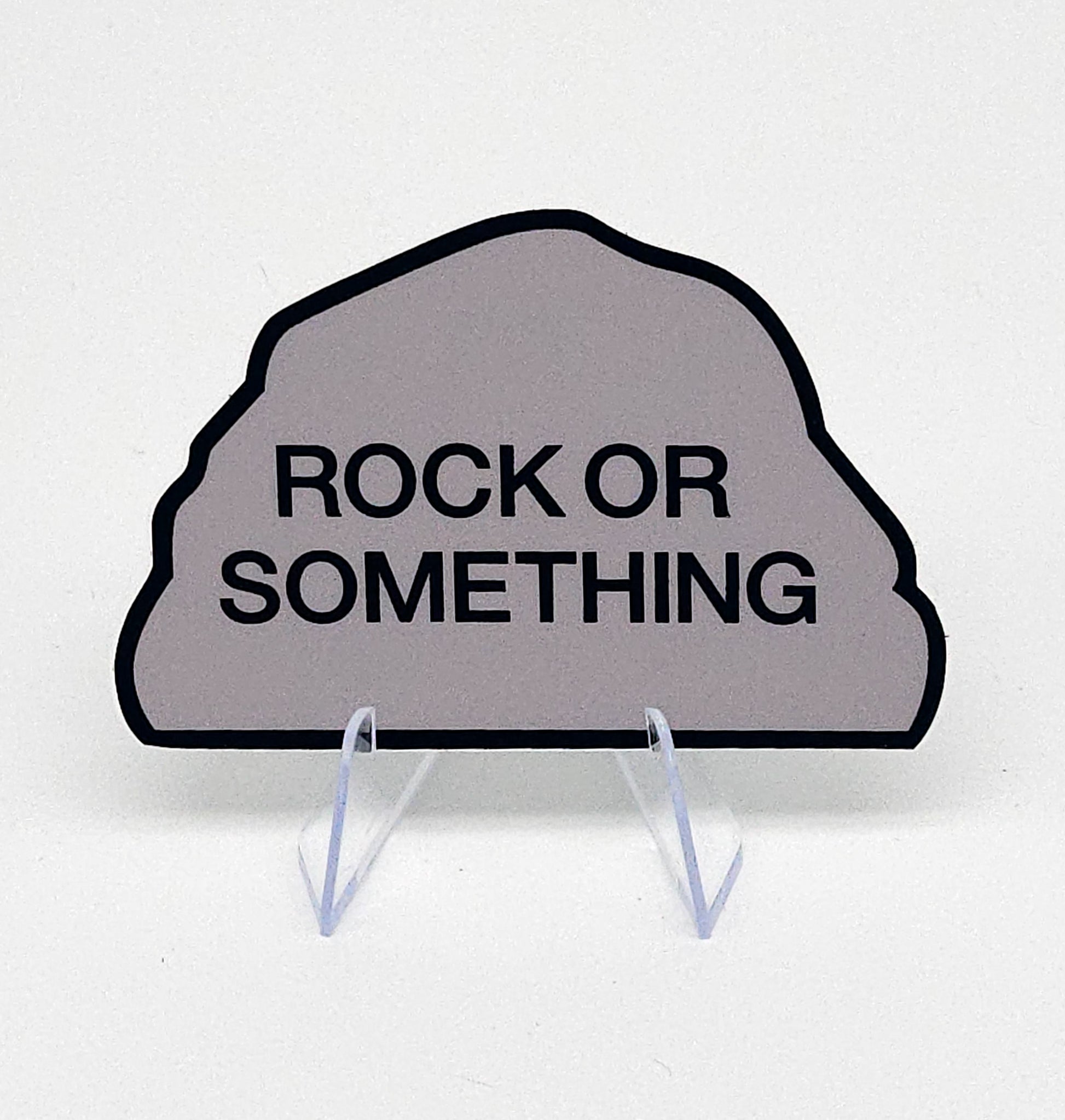 Decorative sign shaped like a rock with 'Rock or Something' text on a white background