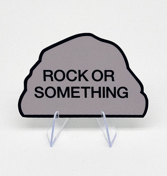 Decorative sign shaped like a rock with 'Rock or Something' text on a white background