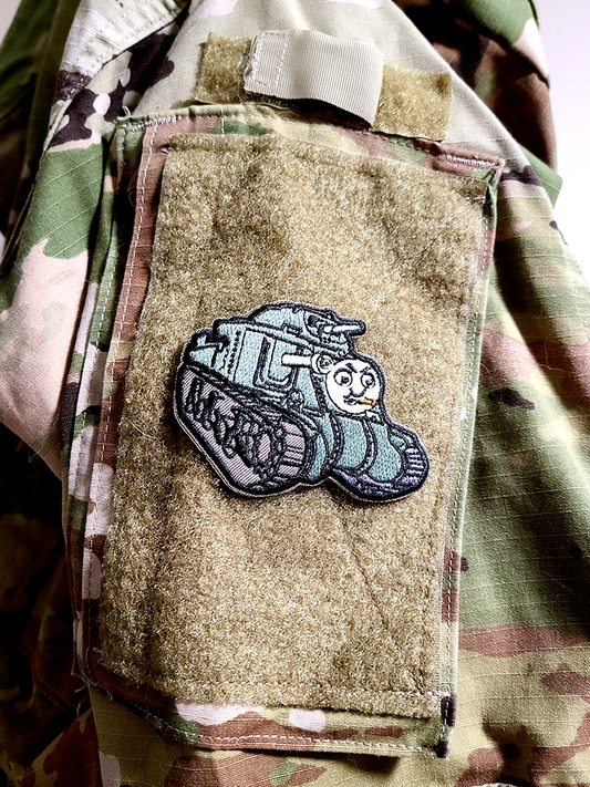 It's Thomas the Tank as a velcro patch. It's a sherman tank with a face chewing on a cigar