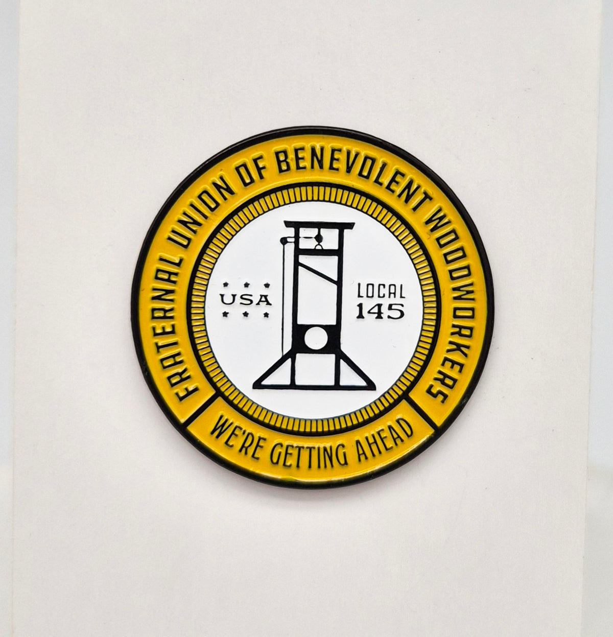 Circular logo with text and a guillotine silhouette on a white background